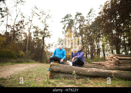 Guide Senior seduti su tronchi di legno, riposo, acqua potabile. Foto Stock