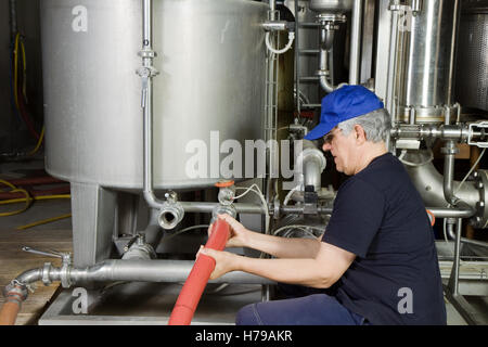Lavoratore Specializzato del montaggio di un impianto di pompa in un'impresa industriale Foto Stock
