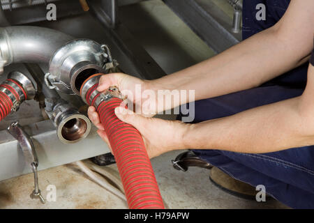 Lavoratore Specializzato del montaggio di un impianto di pompa in un'impresa industriale Foto Stock