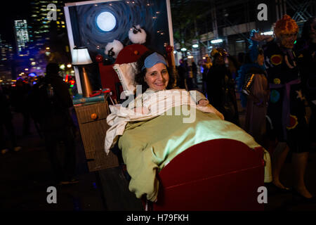 New York, NY - 31 ottobre 2016. Una donna in costume come se nel letto, con una notte di stand, testiera del letto e lo sfondo con un dipinto rem Foto Stock