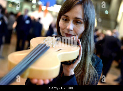 Solo uso editoriale attrice ed Ex Central Saint Martins studente Tara Fitzgerald detiene un violino, che utilizza la qualità vibrante di ragni seta disegnato da vincitore assoluto Luca Alessandrini dall'Italia, in questo anno di International Student Innovation Awards presso il Central Saint Martins, Londra. Foto Stock