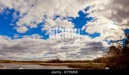 Paesaggio autunnale del fiume e gli alberi senza foglie cielo blu e nuvole in una giornata di sole Foto Stock