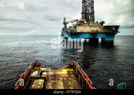 Anchor-Handling Tug/alimentazione (AHTS) nave durante il posizionamento dinamico (DP) operazioni in prossimità dell'impianto di trivellazione petrolifera. Foto Stock