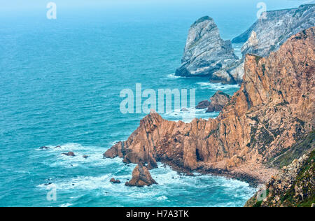 Oceano atlantico costa (massi di granito e scogliere sul mare) in nuvoloso meteo. Vista dal Capo Roca (Cabo da Roca), Portogallo. Foto Stock