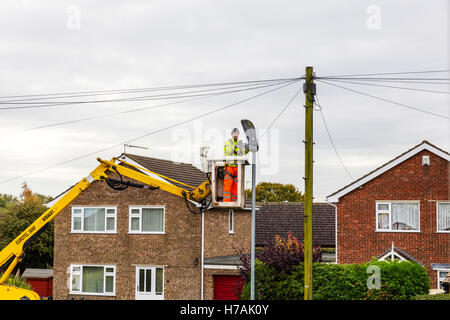 Via la luce riparazione e sostituzione delle lampadine della lampadina fino a lavorare sulla riparazione uomo su cherry picker consiglio spie luci di strada riparazioni ri Foto Stock