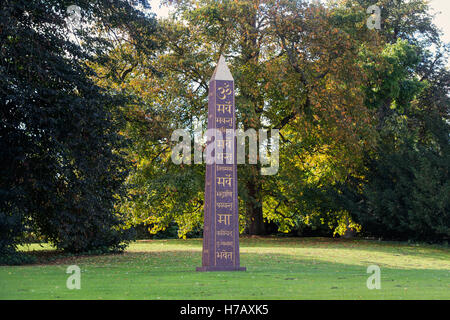 Om e Sanscrito sulla pace Obelisco a Waterperry giardini in autunno, Wheatley, Oxfordshire. Regno Unito Foto Stock