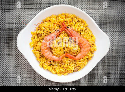 Due gamberi rendendo a forma di cuore su un piatto di tapas di paella spagnola Foto Stock