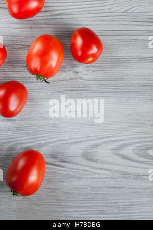 Rossi freschi pomodori in grigio sullo sfondo di legno con spazio di copia Foto Stock