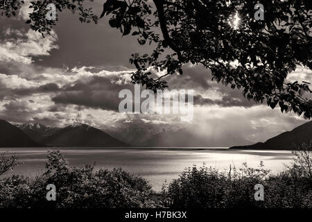 Nuvole temporalesche incombono sulla Chugach Mountains attraverso Turnagain braccio dalla speranza in Alaska centromeridionale. Foto Stock