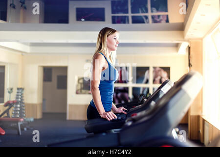 Inquadratura orizzontale di donna jogging sul tapis roulant al club della salute. Lavoro femminile in una palestra in esecuzione su un tapis roulant. Foto Stock