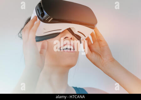 Close up della giovane donna in realtà virtuale auricolare guardando gli oggetti. Modello femminile con la realtà virtuale gli occhiali di protezione contro il GRE Foto Stock