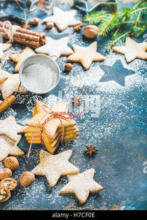 Gingerbread Natale a forma di stella i cookie con cannella, anice e noci servita con abete ramo su scuro dello sfondo di legno compensato, Foto Stock