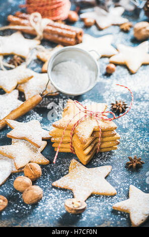 In casa di panpepato a forma di stella i cookie con cannella, anice e i dadi sul blu scuro Compensato verniciato sfondo, il fuoco selettivo Foto Stock