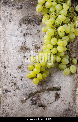 I grappoli di ripe rosso bagnato e uve bianche su vecchie texture di sfondo di metallo. Vista da sopra con spazio per il testo Foto Stock