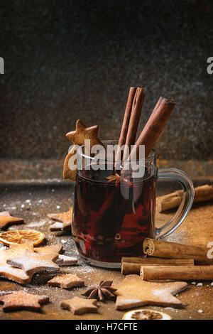 Tazza di vetro di caldo rosso vino brulé spezie, zucchero biscotti frollini forma a stella e cookie sul vetro, anice e cannella in polvere sul Foto Stock