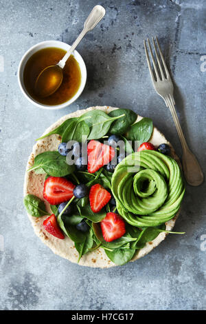 Insalata mista con spinaci,bacche e rose di avocado con miele senape medicazione.vista superiore Foto Stock