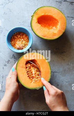 Femmina di movimentazione a mano i semi da un melone.vista superiore Foto Stock