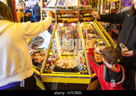 Persone giocare le slot machines in un divertimento arcade alla fiera d'oca, Nottingham, Inghilterra, Regno Unito Foto Stock