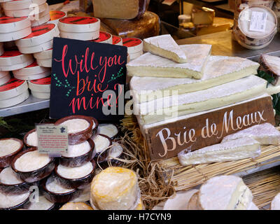 BRIE DE MEAUX con altri formaggi presentati in autentiche (eccentrico) Formaggi francesi in stallo nel mercato di Borough Southwark London REGNO UNITO Foto Stock