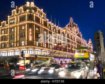 HARRODS VENDITA BLUR LIGHTS ULEZ Harrods grande magazzino di notte con luce 'Sale' segno Shoppers Harrods tour bus e taxi Knightsbridge Londra SW1 Foto Stock