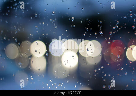 Fotografia di una scena di traffico attraverso un vetro bagnato e con effetto bokeh di fondo Foto Stock