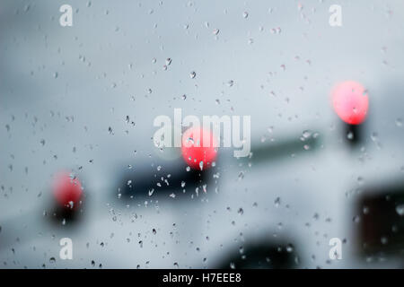 Fotografia di una scena di traffico attraverso un vetro bagnato e con effetto bokeh di fondo Foto Stock