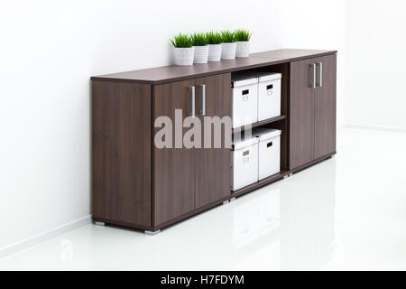 Cabinet in legno contro un muro bianco Foto Stock