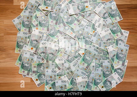 Sfondo di denaro fatte di un centinaio di zloty polacco (PLN) fatture su pavimento in legno Foto Stock