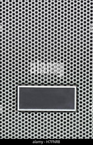 Piastra metallica etichetta sul metallo acciaio griglia con righe ripetitive di perforate fori circolari, background e texture, griglia metallica per ind Foto Stock