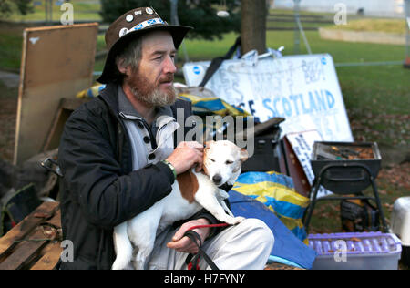 Dean Halliday, uno di un gruppo di attivisti di indipendenza che ha impostato sul campo i motivi del parlamento scozzese di Edimburgo, reagisce come essi sono stati sfrattati. Foto Stock