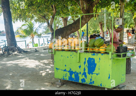 Vendita di stallo di cocco fresco e succo di ananas a fette da spiaggia pubblica di Péreybère, Mauritius Foto Stock