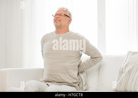 Senior infelice uomo che soffre di mal di schiena a casa Foto Stock