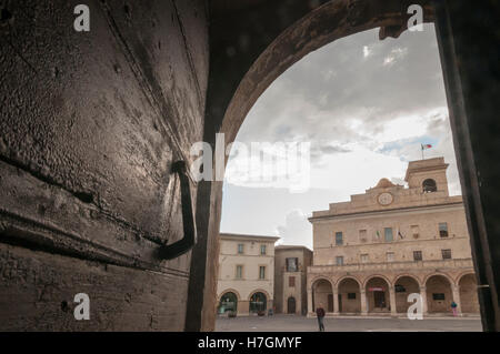 Una vecchia porta con lo sfondo della piazza del comune di Montefalco in Umbria Foto Stock