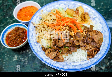 Ciotola tradizionale di vietnamiti bun vermicelli riso stick a base di noodle con insalata di carne charbroiled, shredded carne di maiale, fritte ro a molla Foto Stock