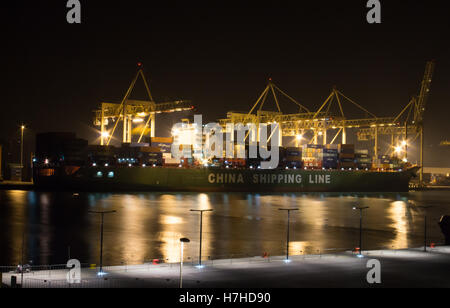 XIN PU DONG - Contenitore nave è in porto Luka Koper durante lo scarico dei contenitori di notte. Foto Stock