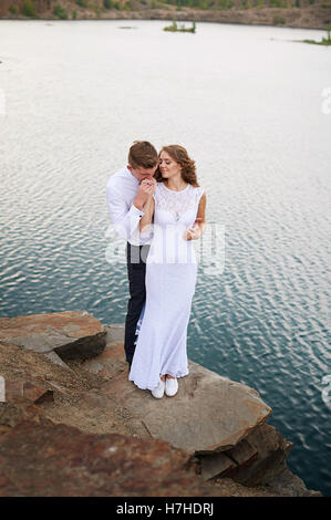 Sposa e lo sposo a piedi vicino al bellissimo lago. Coppie in viaggio di nozze in amore Foto Stock