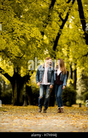 Giovani amare giovane avente una passeggiata nel parco di autunno Foto Stock