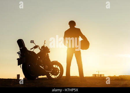 Biker con la motocicletta in corrispondenza di un tempo di tramonto Foto Stock