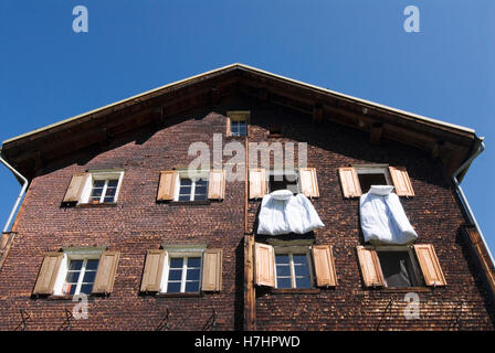 Biancheria da letto appendere fuori delle finestre in una casa di legno in Glas del cantone dei Grigioni, Svizzera, Europa Foto Stock