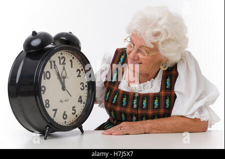 È quasi mezzogiorno, donna anziana con un orologio di allarme Foto Stock