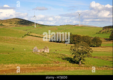 Una vista sul Cabrach con rovinato croft e turbine eoliche in Aberdeenshire, Scotland, Regno Unito. Foto Stock