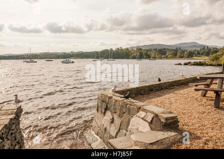 Una vista panoramica del lago di Windermere a Ambleside che mostra le barche a vela ormeggiata sul lago Foto Stock