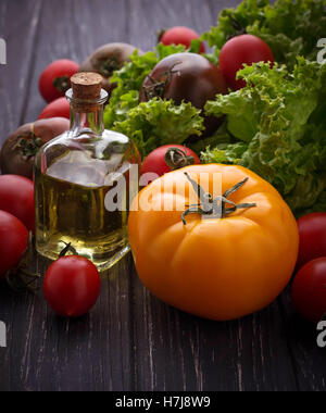 Pomodori colorati su sfondo nero. Messa a fuoco selettiva Foto Stock