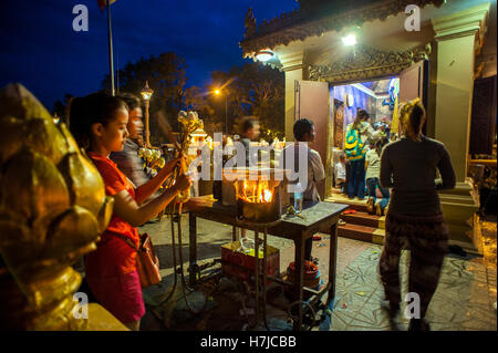 I devoti luce bastoncini di incenso a riverfront santuario in Phnom Penh Cambogia. Foto Stock