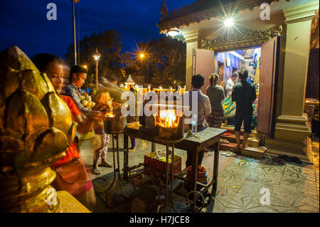 I devoti luce bastoncini di incenso a riverfront santuario in Phnom Penh Cambogia. Foto Stock