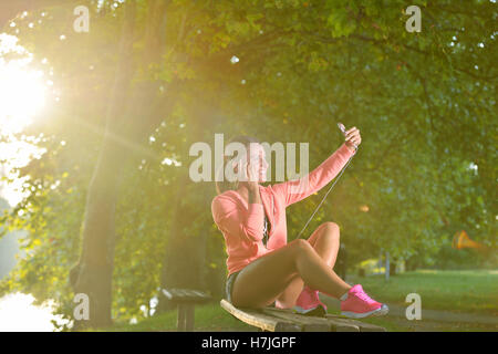 Giovane donna prendendo riposo dopo il jogging - allenamento presso il parco Foto Stock