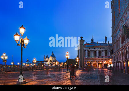 Piazza San Marco lungo il canal Grande in gondola pier con la repubblica di Venezia di simboli su colonne erette verso Santa Maria della Salute Foto Stock