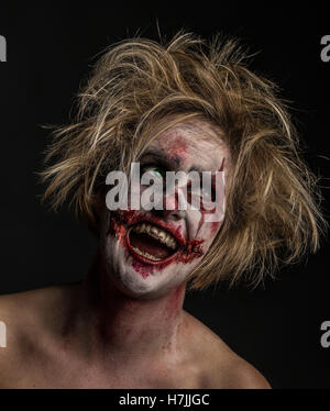 Blonde modello femminile come cruenti, impazzito, folle, omicida, ridendo clown Foto Stock