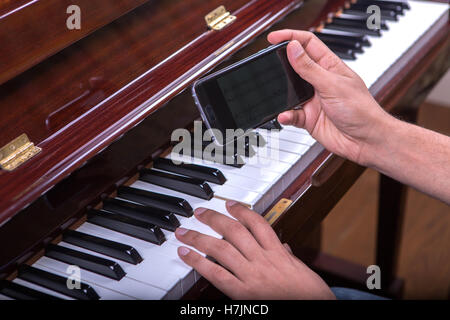 L'uomo suonare pianoforte canzone da mobile 3, con la mano destra Foto Stock