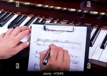 L'uomo suonando piano tune Nascondino Vocaloid scrivere note Foto Stock